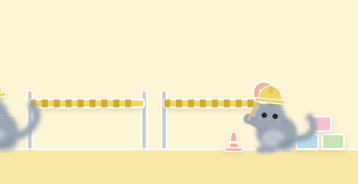 A grey cat pushing a wheelbarrow of blocks past a cat with a stop and go paddle